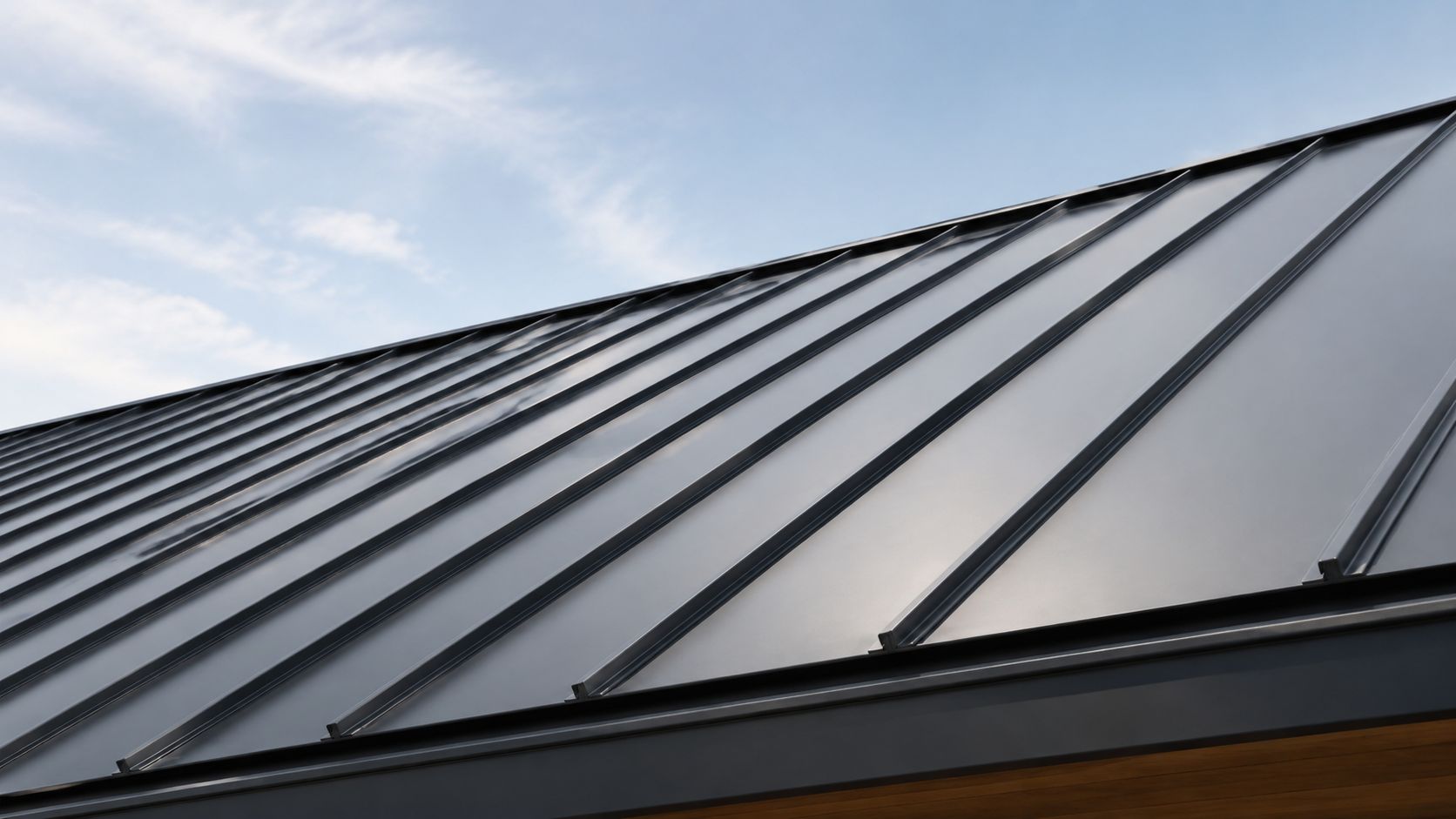 A close-up view of a modern standing seam metal roof against a clear blue sky background.